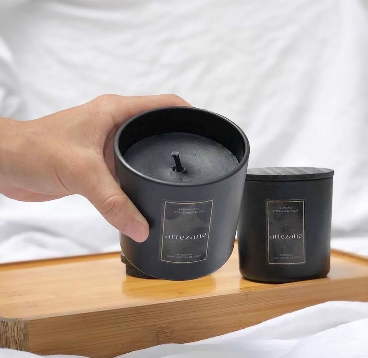 Par de velas Artezane em recipiente preto fosco sobre bandeja de bambu — coleção corporativa Zane
