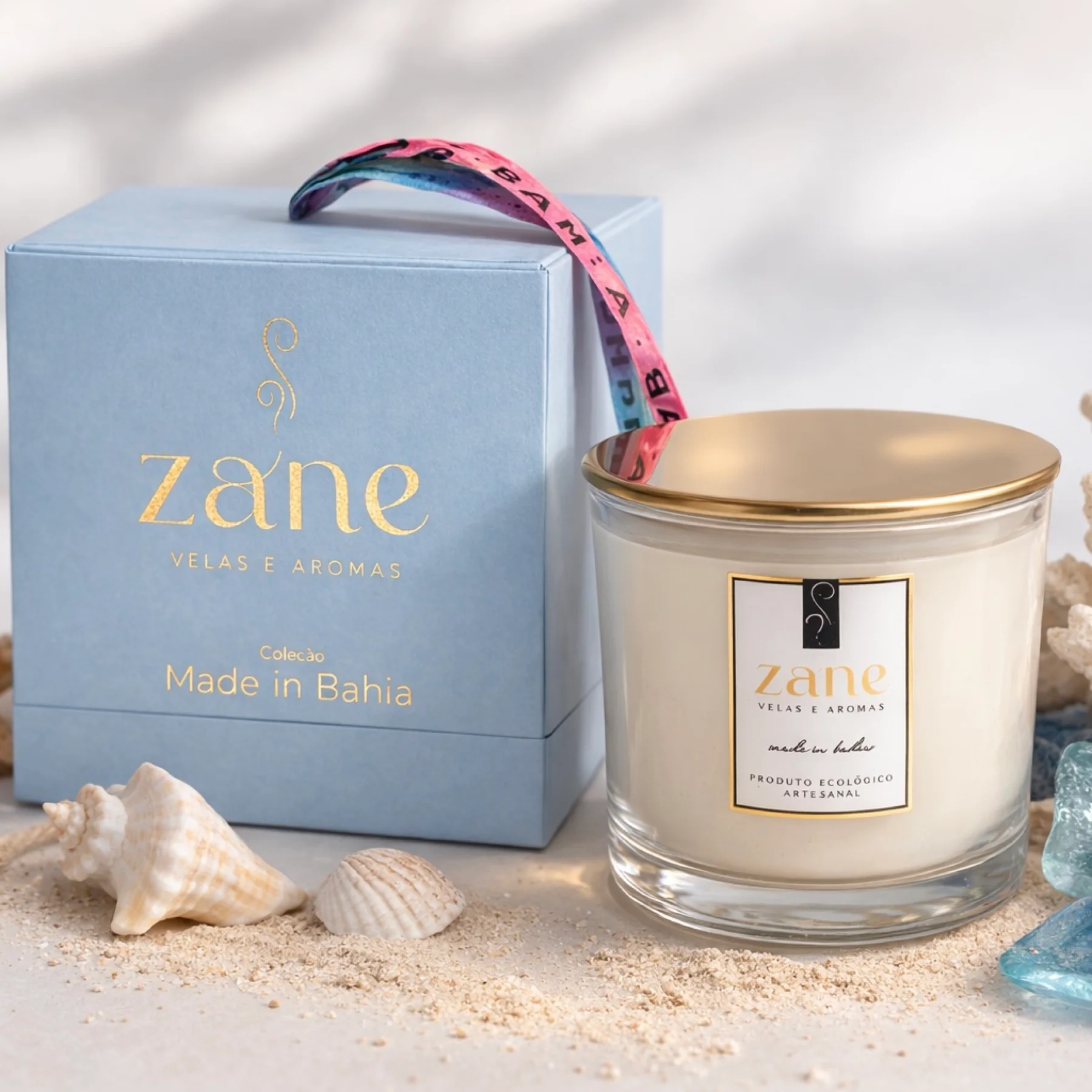 Vela Zane Velas e Aromas — coleção Made in Bahia em frasco transparente com tampa dourada e caixa azul-celeste