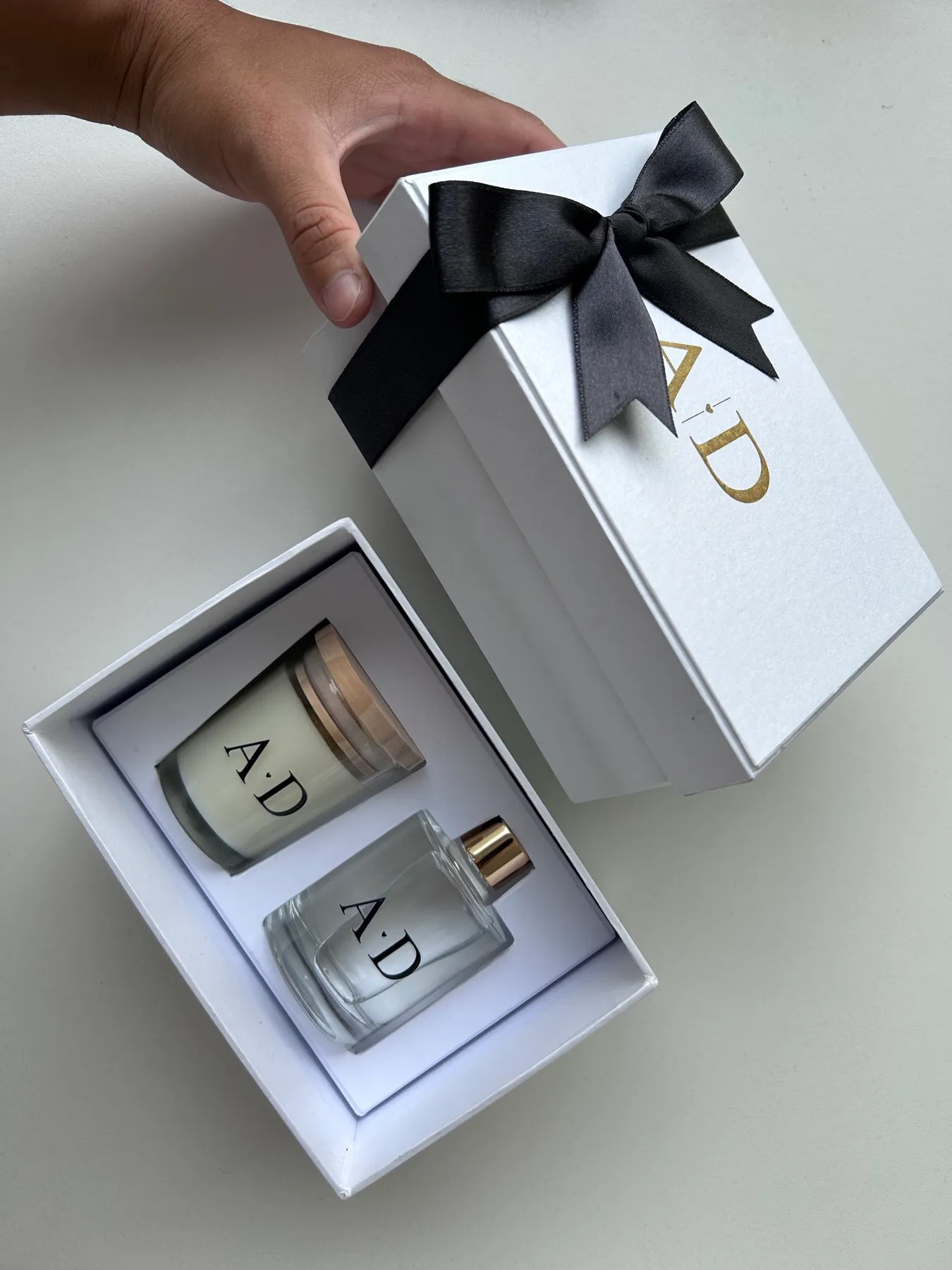 Kit Luxo A•D — vela e aromatizador em caixa branca com laço preto